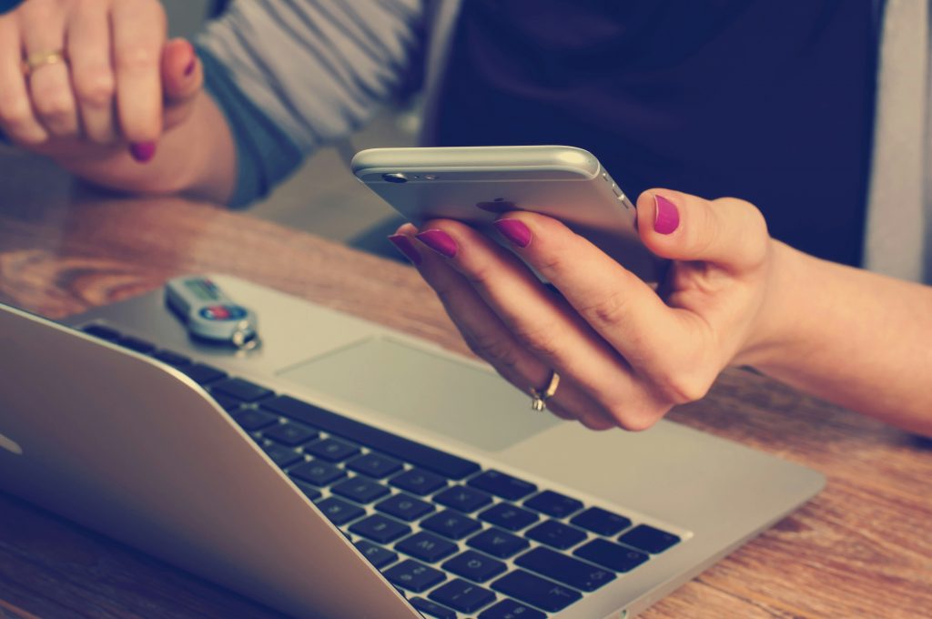 Grafikdesign und Branding für Personal Brands und Coaches – Selbstständige arbeitet am Laptop und Smartphone an digitalem Markenauftritt